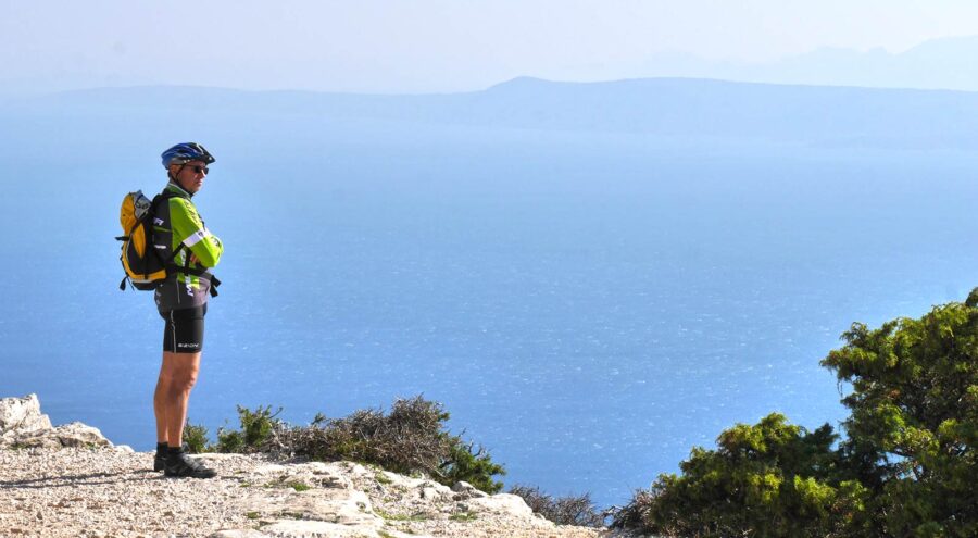 A man in cycling gear standing atop Vidova Gora mount top